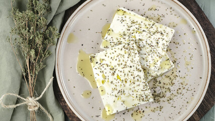 Fresh feta cheese with oregano and olive oil on plate - obrazy, fototapety, plakaty