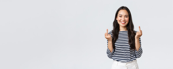 Lifestyle, beauty and fashion, people emotions concept. Unbothered and careless young happy smiling woman dont give a damn, showing middle fingers and feeling good, white background - obrazy, fototapety, plakaty