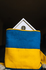 Ukrainian house with national yellow-blue flag. Shelter for homeless people from Ukraine affected...