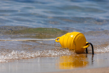 Obraz premium Safety yellow sea buoys floating on the beach