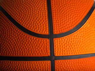 Details of an orange basketball. Macro shot. There are no people in the photo. Abstract Sports games, workouts, healthy lifestyle. Advertising. Banner. Invitation.