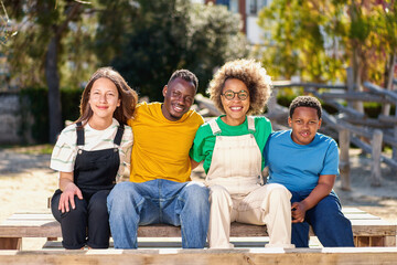 Cheerful multiracial happy family outdoors laughing, smiling multicultural diverse young people group having fun embracing celebrating reunion