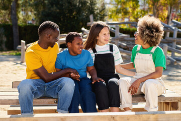 Cheerful multiracial happy family outdoors laughing, smiling multicultural diverse young people group having fun embracing celebrating reunion