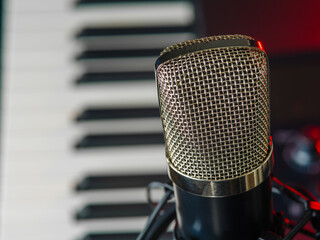 Macro shot. Microphone and midi keyboard, synthesizer. Recording studio, radio, music, place of work of a composer, musician, vocalist. Home music studio. Concert invitation.