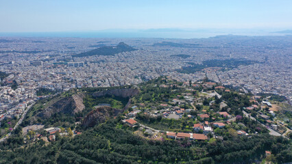 Fototapeta na wymiar Aerial drone photo of famous hill of Tourkovounia with great view to Athens cityscape near alsos of Veikou and Galatsi area, Attica, Greece