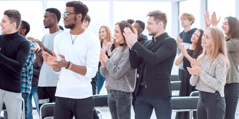 group of diverse young people applauding together.