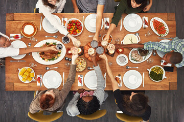 Good food is even better with good friends. Shot of a group of people sitting together at a dining table ready to eat.