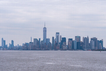 Naklejka premium The Freedom Tower and the buildings of lower Manhattan financial district downtown as seen from New York Harbor