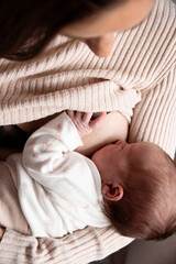 Breastfeeding vertical baby and mum. Brown sweater in earth tones