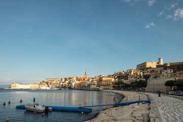 The embankment of a small Italian town Gaeta on sunset with town buildings visible in the distance