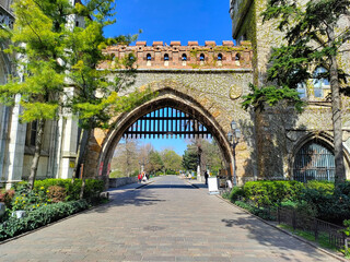 Historical romantic gate in the style of medieval castle with massive iron bars. The gate is the main entrance into the museum.