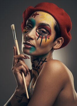 The beauty is inside you. Studio shot of a young woman posing with paint on her face on a grey background.