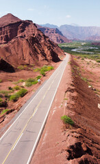 Northern Argentine route, bordered by a river and surrounded by a landscape of red earth.
