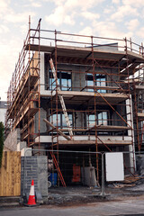 Town residential house building. Modern home construction site with scaffolding. Nobody.