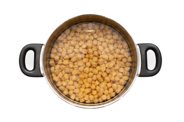 Soaking chickpeas in a metal pot. Isolated on white background. Preparing a widely consumed meal at Easter, chickpeas with cod.