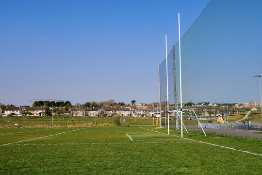 Irish National sports training field with goal posts for Gaelic sports camogie, hurling, irish football, rugby and soccer. Cloudy sky. Residential area with houses in the background. Galway, Ireland