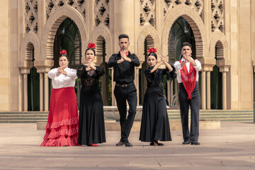spanish group of flamenco dancers playing hand clapping in a group