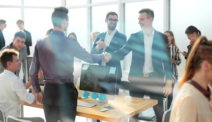 through the glass. young business people, confidently shaking hands.