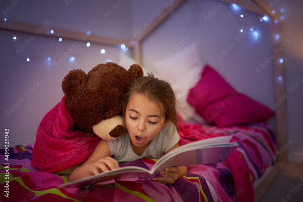 Poster Its a story full of wonderful surprises. Cropped shot of a little girl reading a book in bed with her teddybear.