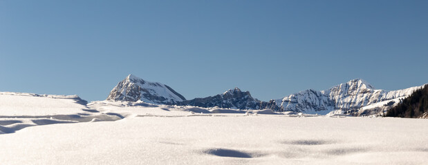 illustration d'un paysage de montagne représenté en premier plan par une vaste étendue enneigée et en second plan par la montagne en vue panoramique