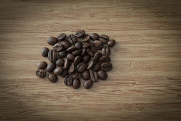 Fresh roasted coffee beans on wooden background.