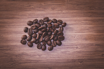 Fresh roasted coffee beans on wooden background.