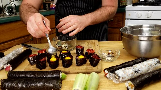 Home cooking - Making battleship sushi using rice, salmon caviar, quell egg yolk and  nori as wrapping.