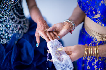 Obraz na płótnie Canvas Indian bride's hands, gloves, rings, mehendi and jewellery close up