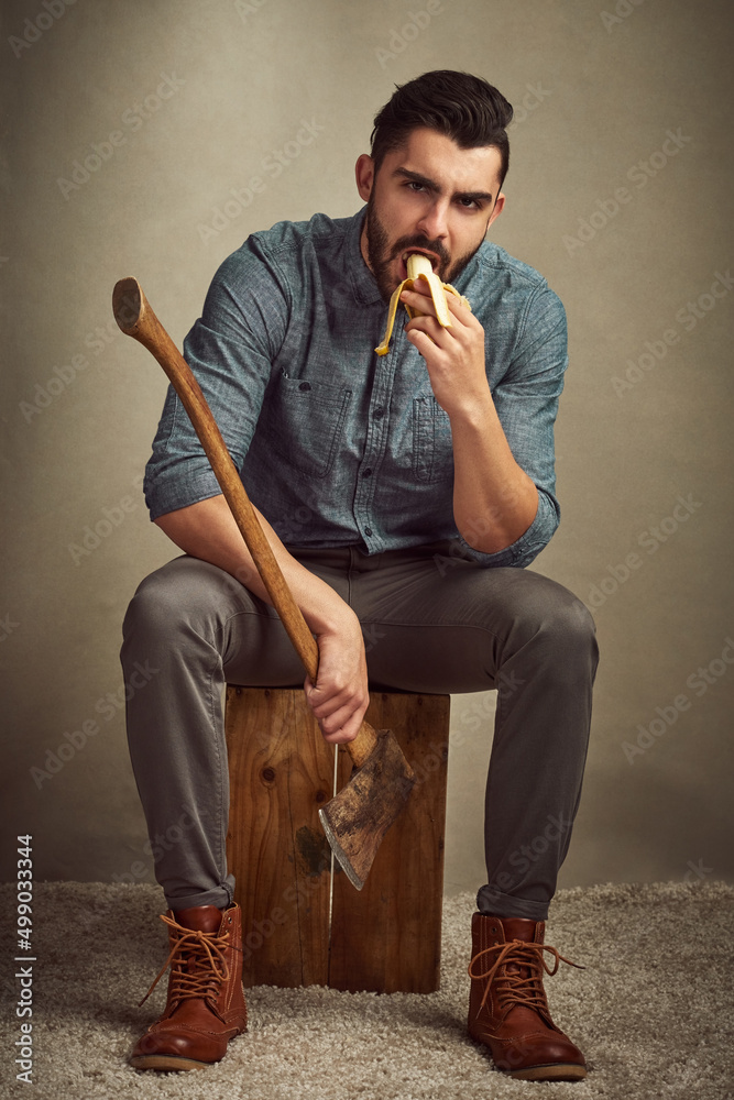 Poster he keeps it healthy and strong. studio shot of a young man posing with an axe against a green backgr