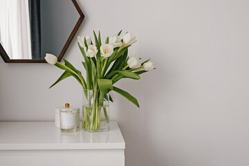 White tulips in the vase in a clean white room.