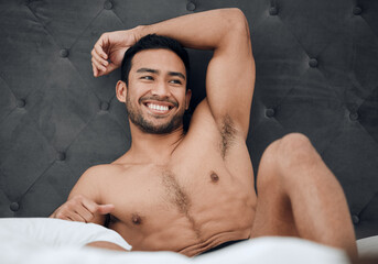 Keep feeding yourself positive thoughts. Shot of a handsome young man lying on his bed.