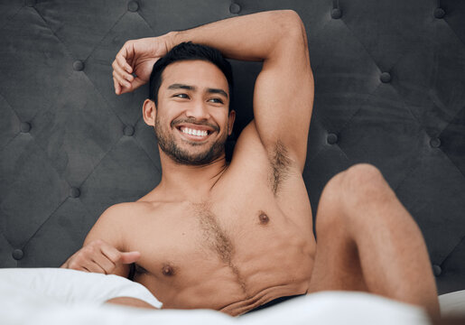 Keep feeding yourself positive thoughts. Shot of a handsome young man lying  on his bed. Stock Photo | Adobe Stock