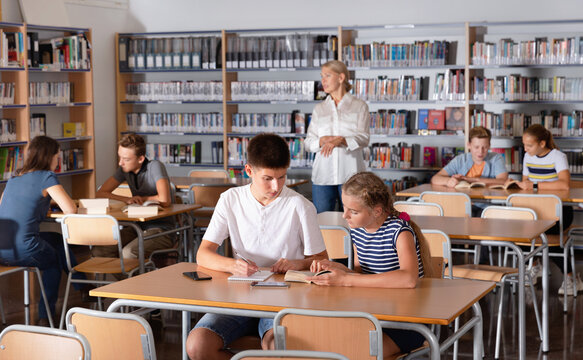 Diligent Efficient Serious Schoolchildren Preparing For Lesson In School Library, Reading And Writing