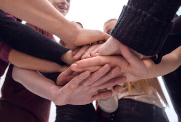 group of diverse young people making a tower out of their hands