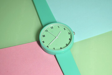 green watch with a rubber strap on a bright colored background