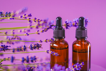 Lavender oil.Aromatherapy and massage.Brown glass bottles oil set and lavender flowers on a purple...