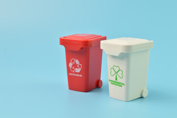 Red and white plastic trash can isolated on a blue background