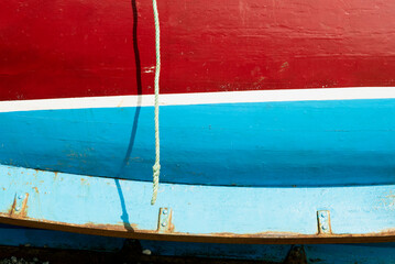 Side of red and blue boat with the keel on the bottom of the hull