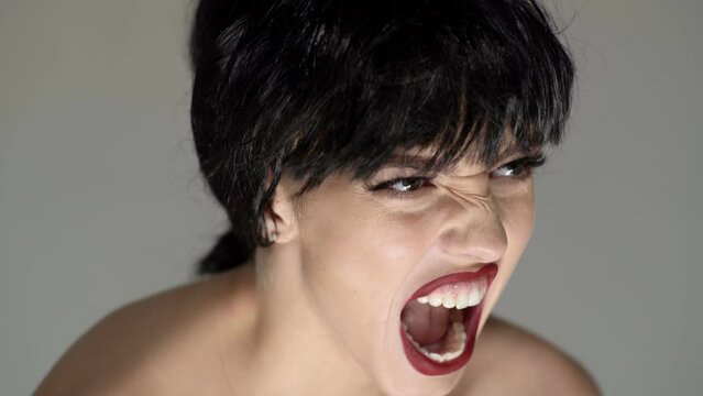 Angry stressed woman screaming with anger and rage. Sad woman face closeup.