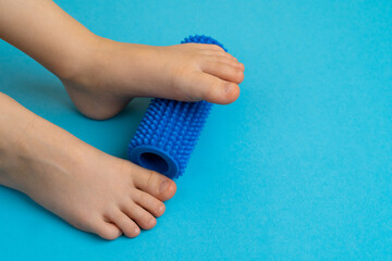 blue needle roller for massage and physiotherapy on a blue background with the image of a child's...