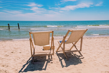 Fototapeta na wymiar Two chairs on the beach near the sea