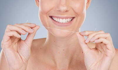 Its not enough to simply brush. Studio shot of an unrecognizable young woman using dental floss against a grey background.