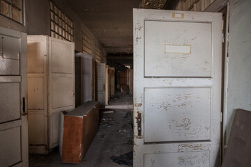 Selective blur on a lobby Interior of an abandoned office building, in a dirty and damaged corridor with old papers remaining after the closure and the bankruptcy of the business