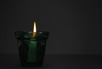 The candle burns on a black background. Tragedy and memory.