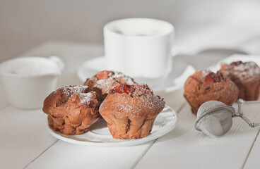 homemade chocolate muffins with berry filling and a cup of coffee on wooden table. home baking, tasty breakfast for weekend.