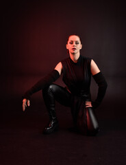 Full length portrait of pretty redhead female model wearing black futuristic scifi leather cloak...