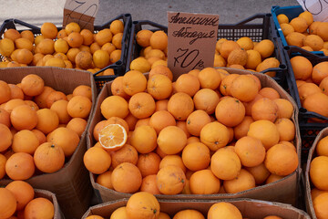 The market sells oranges in cardboard boxes from Abkhazia. Oranges from Abkhazia are written on the cardboard, 70 rubles.