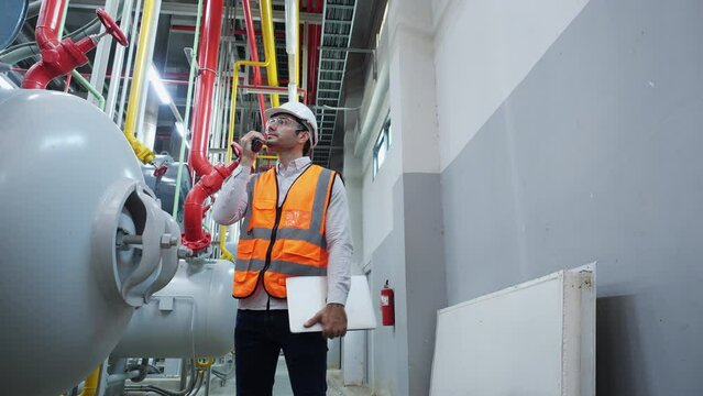 Industrial engineer working and communication for inspect factory and machine standards. Engineer male working at factory. Concept of industry, factory, environment and professional people.
