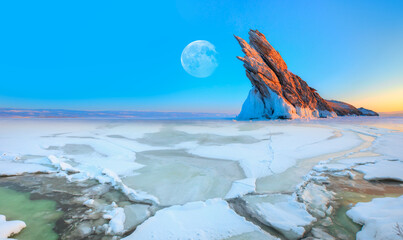 The ice on Lake Baikal is melting - Ogoy island on winter Baikal lake with transparent cracked blue ice at sunrise - Baikal, Siberia, Russia