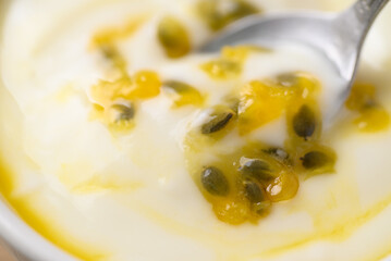 Close up of yogurt with passion fruit juice in bowl with spoon, Healthy eating